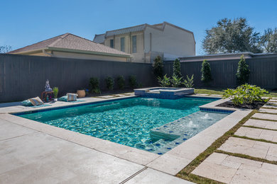 Mid-sized trendy backyard stone and rectangular pool photo in Houston
