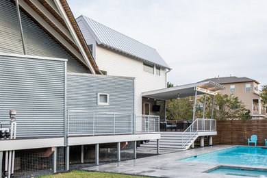 Стильный дизайн: большой спортивный, прямоугольный бассейн на заднем дворе в стиле модернизм с джакузи и покрытием из бетонных плит - последний тренд