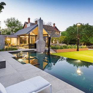Large contemporary backyard rectangular infinity pool in Melbourne with a hot tub.