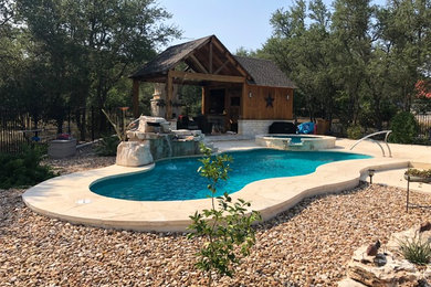Pool - large modern backyard stone and custom-shaped pool idea in Austin