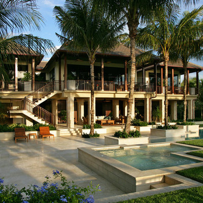 Example of an island style backyard tile and custom-shaped lap pool design in Miami
