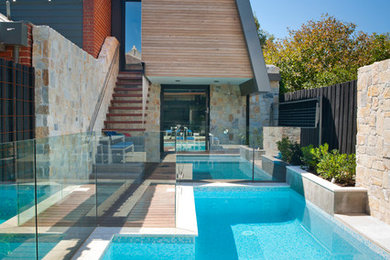 Imagen de piscina actual rectangular en patio trasero