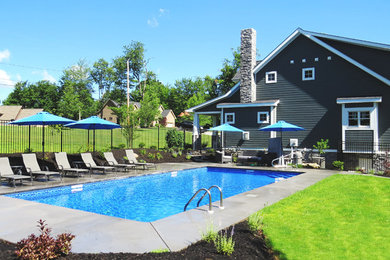 Imagen de piscina alargada tropical grande rectangular en patio trasero con losas de hormigón