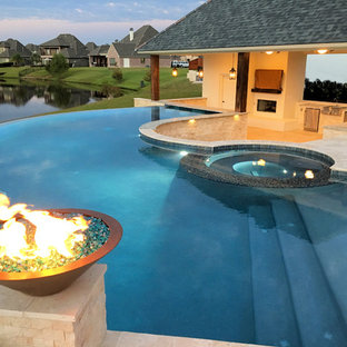Ispirazione per una grande piscina a sfioro infinito minimal personalizzata dietro casa con una dépendance a bordo piscina e pedane