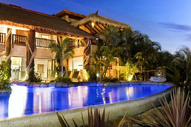 Diseño de piscina con fuente natural tropical extra grande a medida en patio trasero con adoquines de piedra natural
