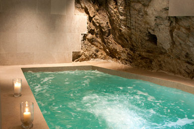 Ispirazione per una piscina coperta mediterranea rettangolare con piastrelle e una vasca idromassaggio