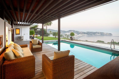 Cette image montre une piscine arrière design de taille moyenne et rectangle avec une terrasse en bois.