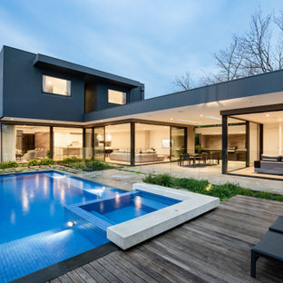 Contemporary backyard rectangular pool in Melbourne with a hot tub and decking.