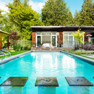 Imagen de casa de la piscina y piscina alargada, vintage, de tamaño medio, rectangular, en patio trasero, con adoquines de hormigón
