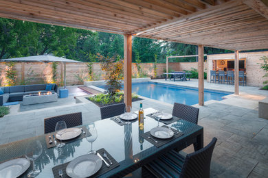 Foto de casa de la piscina y piscina actual grande rectangular en patio trasero con adoquines de piedra natural