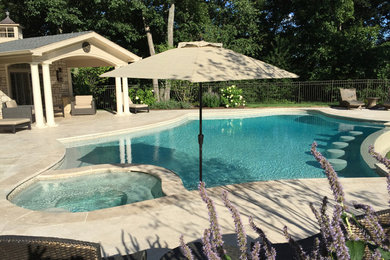 Immagine di un'ampia piscina a sfioro infinito tradizionale personalizzata dietro casa con una dépendance a bordo piscina e piastrelle