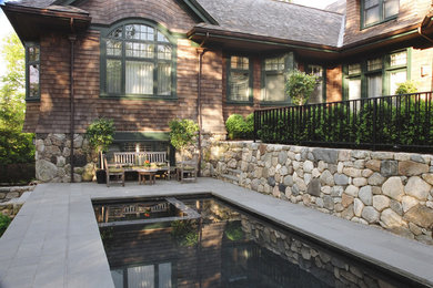 Diseño de piscinas y jacuzzis tradicionales de tamaño medio rectangulares en patio trasero con adoquines de piedra natural