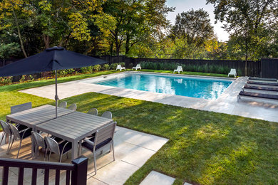 На фото: прямоугольный бассейн среднего размера на заднем дворе в стиле модернизм с покрытием из каменной брусчатки с