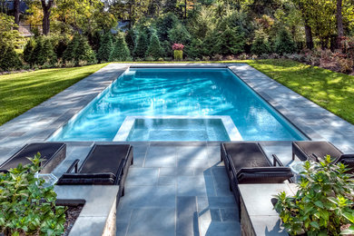 Imagen de piscina tradicional grande rectangular en patio trasero con adoquines de piedra natural