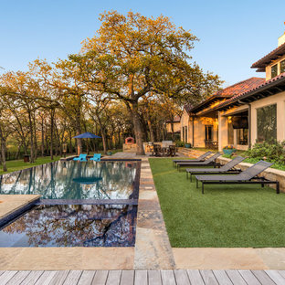Immagine di una piscina a sfioro infinito mediterranea a "L" dietro casa con una vasca idromassaggio e pedane