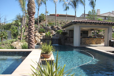 Example of a large trendy backyard stone and rectangular aboveground hot tub design in Orange County