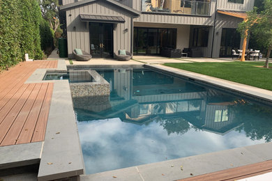 Pool - mid-sized modern backyard rectangular pool idea in Los Angeles with decking