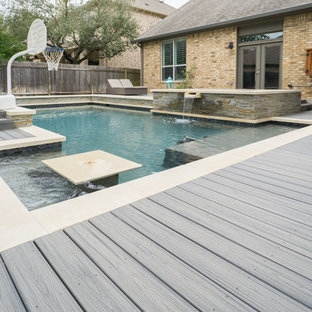 Esempio di una grande piscina design rettangolare dietro casa con una vasca idromassaggio e pedane