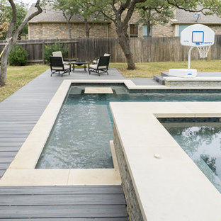 Esempio di una grande piscina design rettangolare dietro casa con una vasca idromassaggio e pedane