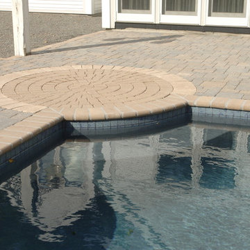Circular pattern in stone breaks up a large area and enhances the pool