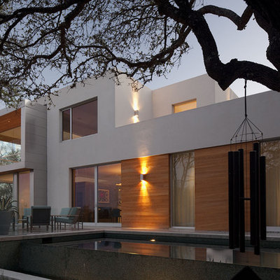 Example of a large trendy backyard concrete paver and rectangular infinity pool design in Austin