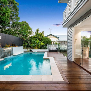 Inspiration for a transitional backyard rectangular natural pool in Brisbane with a water feature and decking.