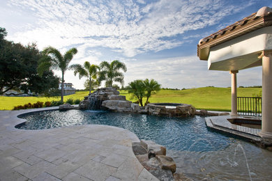 This is an example of a mediterranean custom shaped natural swimming pool in Tampa.