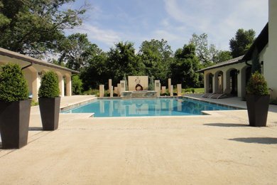 Imagen de piscina con fuente mediterránea grande rectangular y interior con losas de hormigón