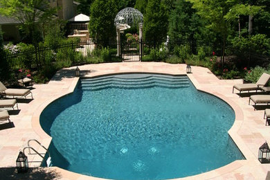Pool fountain - traditional backyard stone and custom-shaped pool fountain idea in New York
