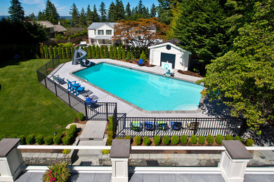 Example of a large classic backyard concrete paver and custom-shaped lap water slide design in Seattle
