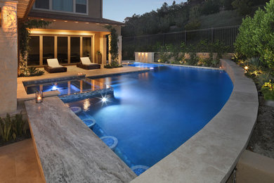 Pool fountain - mid-sized coastal stone and l-shaped pool fountain idea in Orange County