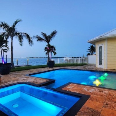 Mid-sized island style backyard stone and rectangular lap hot tub photo in Orlando