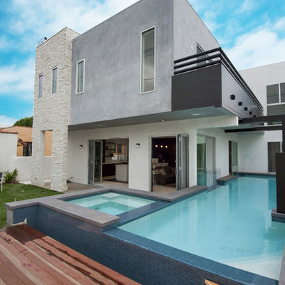 Mid-sized trendy backyard l-shaped aboveground hot tub photo in Los Angeles with decking