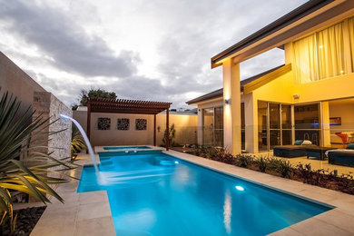 Foto de piscina alargada actual de tamaño medio rectangular en patio trasero