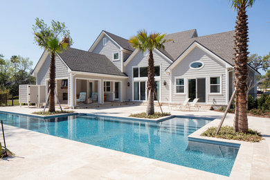 Imagen de piscina alargada costera de tamaño medio rectangular en patio trasero con adoquines de hormigón