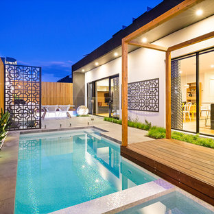 Inspiration for a contemporary side yard custom-shaped lap pool in Melbourne with a hot tub and concrete pavers.