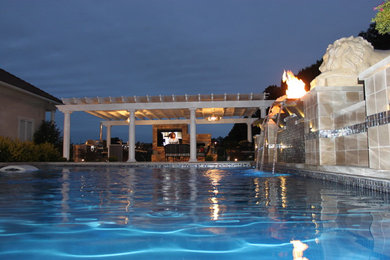 Foto de piscina con fuente mediterránea grande rectangular en patio trasero con adoquines de piedra natural