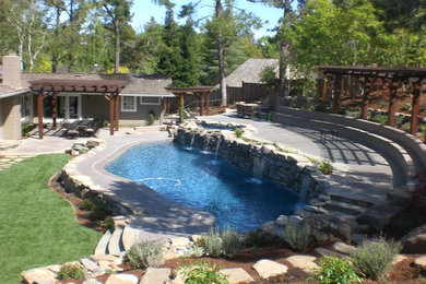 Imagen de piscina con fuente alargada rural de tamaño medio a medida en patio trasero con adoquines de piedra natural