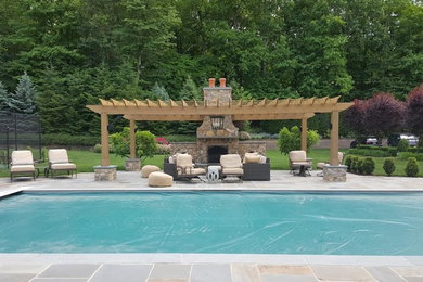 Diseño de piscina alargada clásica renovada grande rectangular en patio trasero con suelo de baldosas