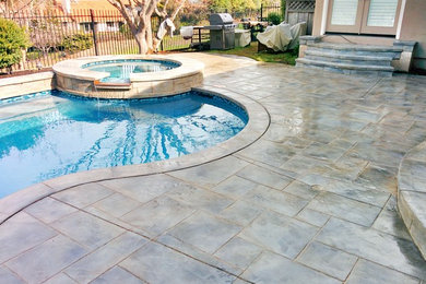 Large classic back custom shaped natural swimming pool in San Francisco with stamped concrete.