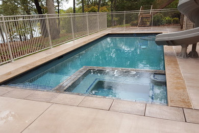 Diseño de piscinas y jacuzzis clásicos de tamaño medio rectangulares en patio trasero con losas de hormigón