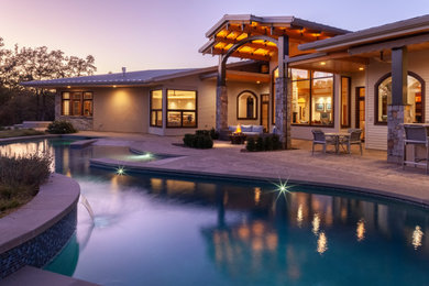 Imagen de piscina de estilo americano grande en patio trasero con adoquines de hormigón
