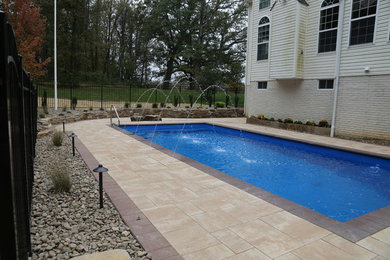 Example of a mid-sized mountain style backyard concrete paver and rectangular pool fountain design in DC Metro