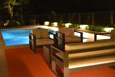 Ejemplo de piscina alargada actual de tamaño medio rectangular en patio trasero con losas de hormigón