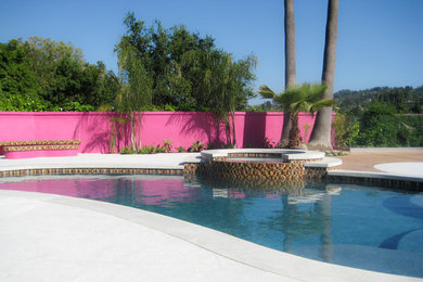 Example of a large trendy backyard stamped concrete and custom-shaped natural hot tub design in Los Angeles