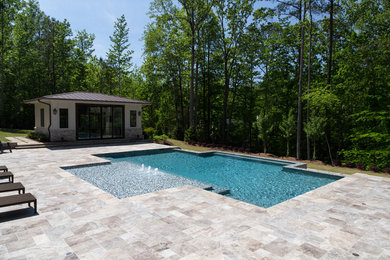 Imagen de casa de la piscina y piscina infinita contemporánea grande rectangular en patio trasero con suelo de baldosas