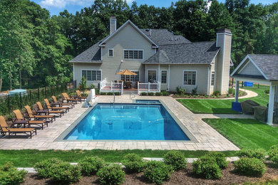 Идея дизайна: большой прямоугольный, естественный бассейн на заднем дворе в стиле неоклассика (современная классика) с домиком у бассейна и мощением тротуарной плиткой