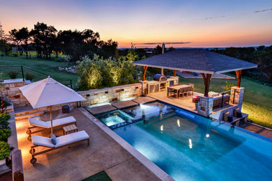 Example of a trendy backyard rectangular infinity pool design in Austin