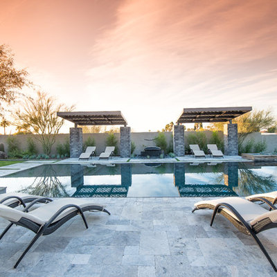 Inspiration for a large contemporary backyard stamped concrete and rectangular infinity pool remodel in Phoenix