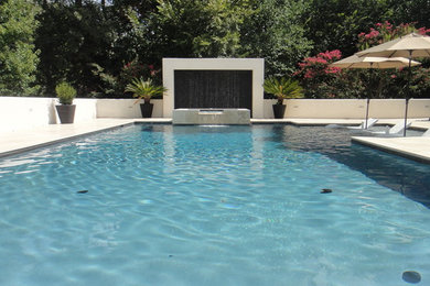 Diseño de piscina con tobogán actual grande rectangular y interior con suelo de baldosas